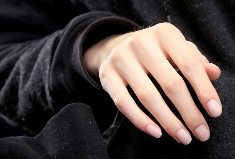 proposta di tendenza unghie color cipria con top coat lucido maglia nera a manica lunga