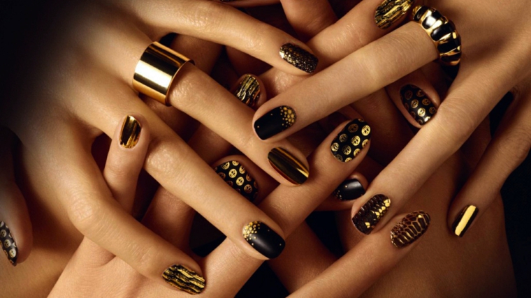 Decorazioni unghie di colore nero con print in oro, abbinamento agli anelli 