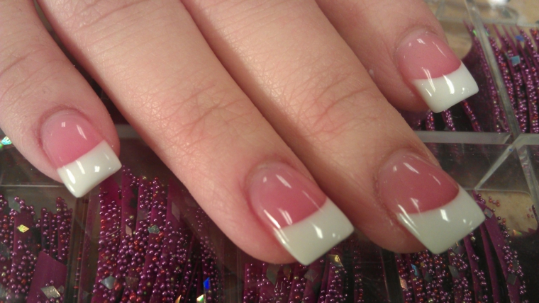 unghie lunghe e dalla forma squadrata rese eleganti dalla franch manicure con base rosa lucida