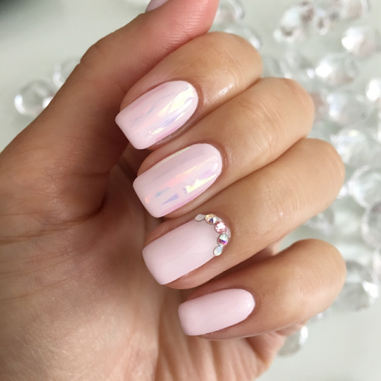 unghie rosa antico nella nuance più chiara con delle decorazioni realizzate con glitter e smalto argento