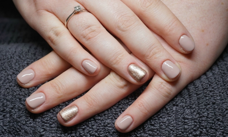 esempio di unghie color carne con l'anulare dorato, mani ben curate con un anello